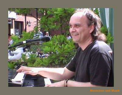 Andreas Mayer strahlt bei Sonnenschein am Piano